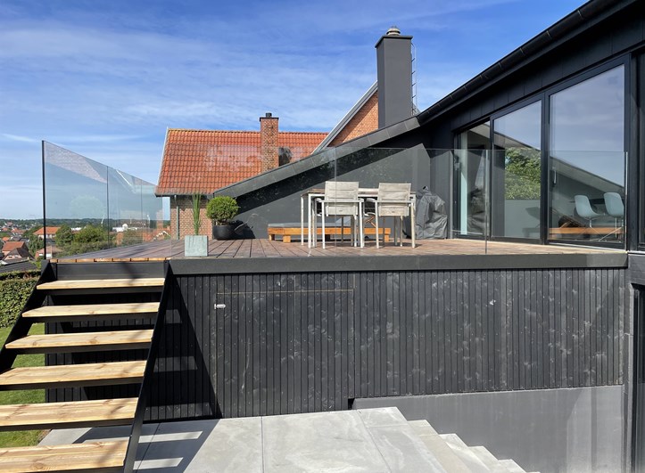 Terrasse med glas værn og trappe ned til have